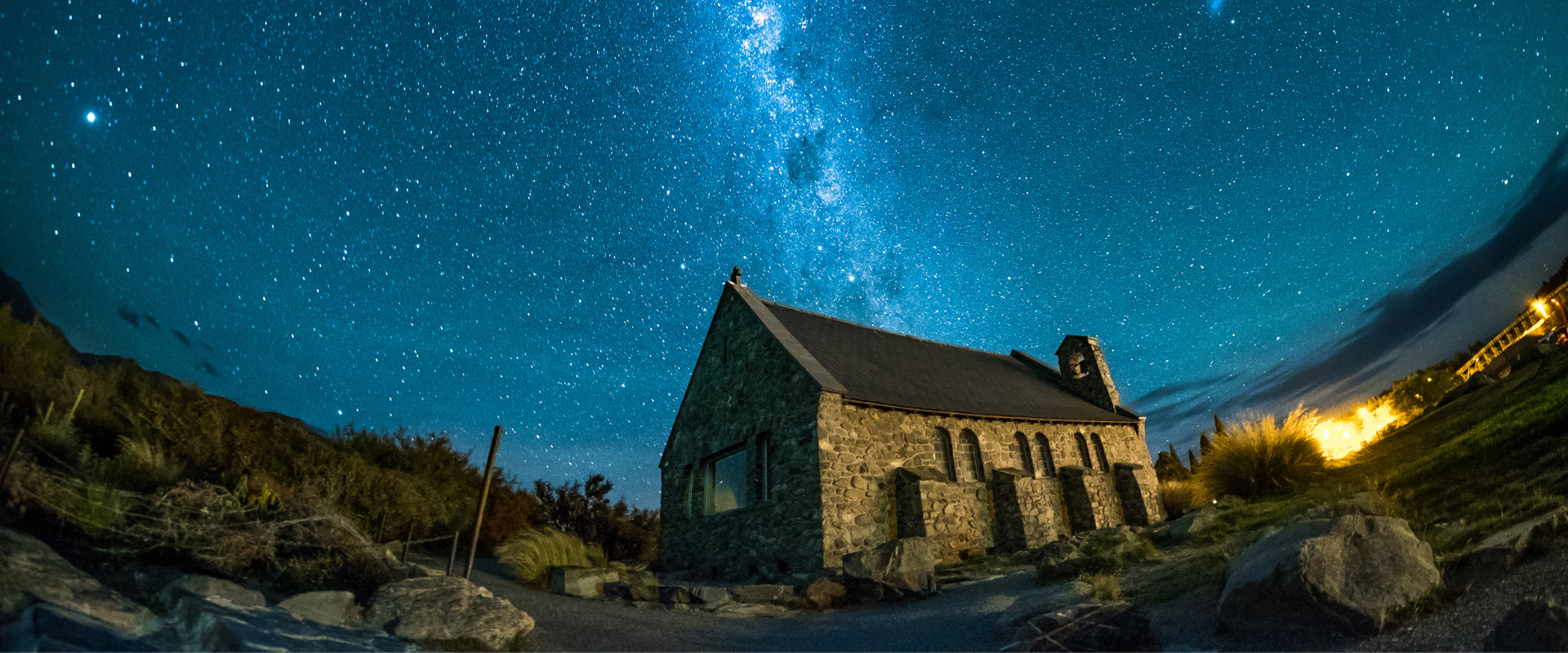 Stone cottage under a starry night sky with the Milky Way visible